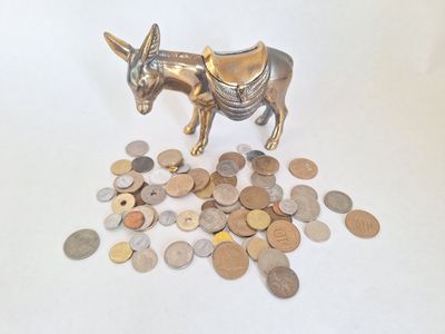 une statue de taureau et quelques pièces de monnaie posées sur une table