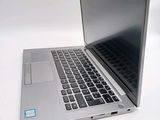 a silver laptop with a black keyboard on a white surface