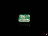 a green emerald stone on a black surface