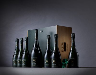 six bouteilles de champagne dans un coffret en bois orné d'un ruban vert