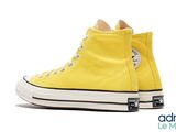 a close up of a pair of yellow converses on a white background