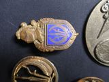 some gold and blue pins and a coin on a black surface
