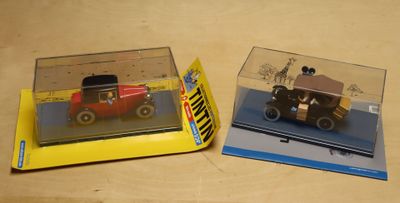 two toy cars that are in a box on a table