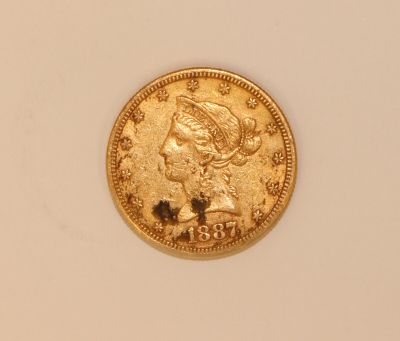 a close up of a gold coin on a white surface