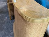 several wicker chairs are lined up in a row in a warehouse