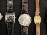 four different types of watches are lined up on a black surface