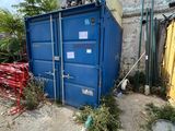 a blue container sitting in the middle of a dirt field