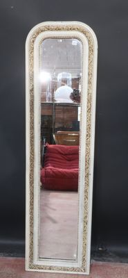 a mirror that is sitting on the floor in front of a red couch