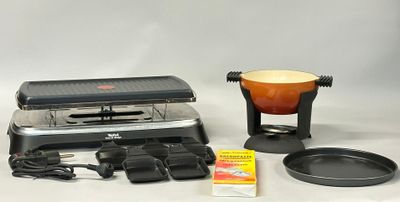 a black and silver grill with a red pot and pan on it