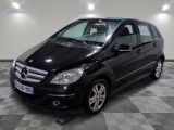une photo d'une mercedes noire de classe b garée sur un sol en damier