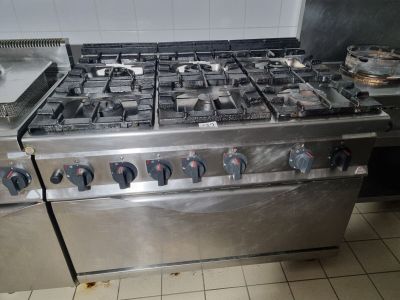a silver stove with four burners and a pot on top of it