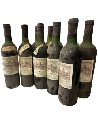 six bouteilles de vin sont alignées sur une surface blanche