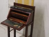 a small wooden desk with a book on it