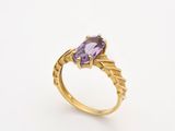 une bague en or sertie d'une pierre d'améthorate au centre
