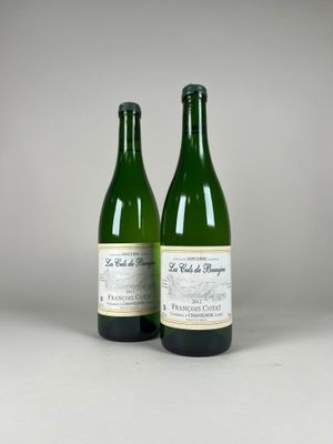 two bottles of wine sitting next to each other on a table