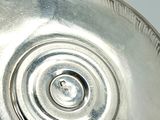a silver plate with a circular design on it