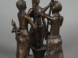 bronze statue of a group of people with a bucket of water