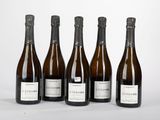 six bouteilles de vin sont alignées sur une surface blanche