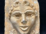 une image représentant une sculpture en pierre représentant le visage d'une femme sur fond noir