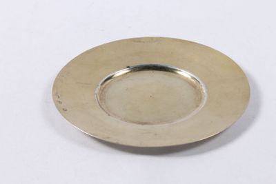 une photo d'une assiette en argent posée sur une table blanche
