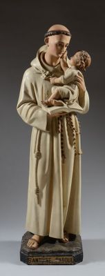 figurine représentant un moine tenant un enfant dans ses bras