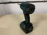 a close up of a cordless drill on a table in a room