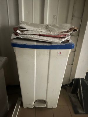 une poubelle blanche avec un couvercle bleu à côté d'une poubelle blanche