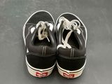 pair of black and white sneakers with white laces on a gray surface