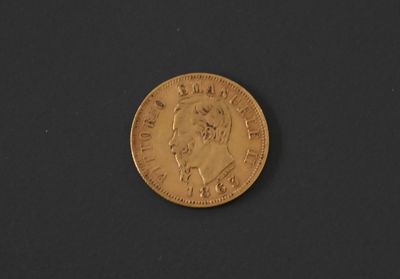 a close up of a gold coin on a black surface
