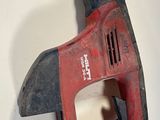 a red and black cordless nailer on a white surface
