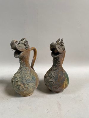 deux vases posés l'un à côté de l'autre sur une surface blanche