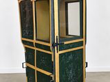 une photo d'une petite vitrine verte et dorée dans une pièce