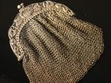 an antique silver mesh purse on a black background