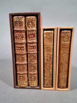 trois vieux livres dans une boîte en bois posée sur une table