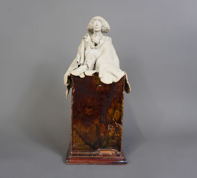 une image représentant une statue d'une femme assise sur une boîte