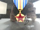 une personne tenant une médaille sur laquelle figure une étoile rouge