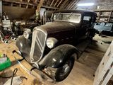 une vieille voiture dans un garage rempli d'outils