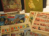 quelques vieilles bandes dessinées sont posées sur une table blanche
