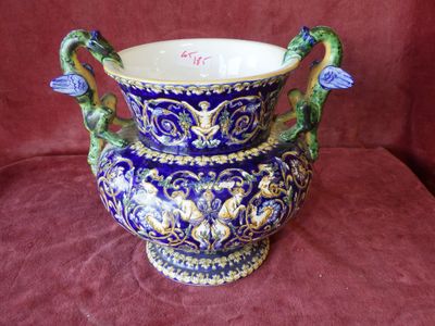 a blue and gold vase sitting on a red cloth