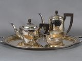 a silver tea set on a silver tray on a table