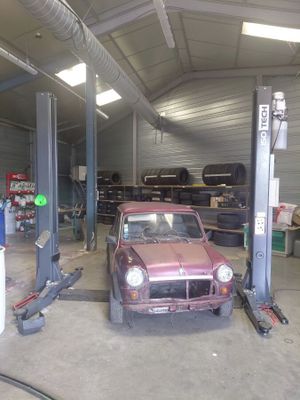 une voiture posée sur un pont élévateur dans un garage