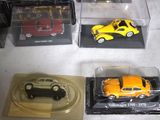several toy cars are in a display case on a table