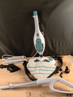 Quelqu'un utilise un balai vapeur pour nettoyer le plateau d'une table.