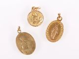 three gold - plated pendants depicting the virgin of guadalupe and the virgin of guadalupe