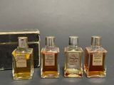 three bottles of perfume sitting next to a box on a table