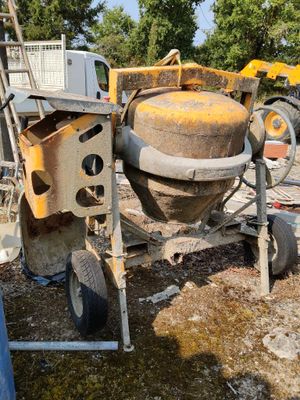 a cement mixer that is sitting on the ground