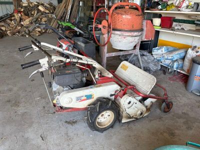 un petit cyclomoteur rouge et blanc garé dans un garage