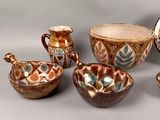 many different types of pottery on display on the table