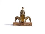 statue représentant une femme et un chien, posée sur un socle en bois