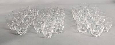 six verres à vin transparents sont alignés sur une surface blanche